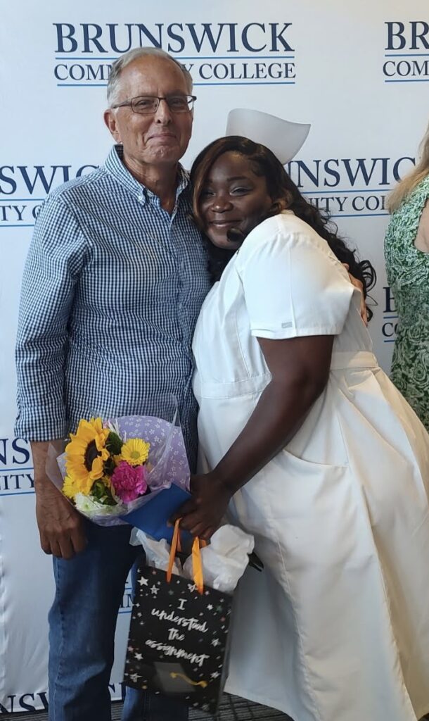 Allen stands proudly with a student after her graduation from community college